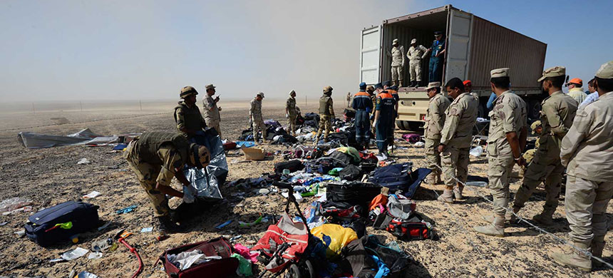 Egyptian soldiers collect passengers' belongings at the crash site. (photo: Russian Ministry for Emergency Situations/AP)
